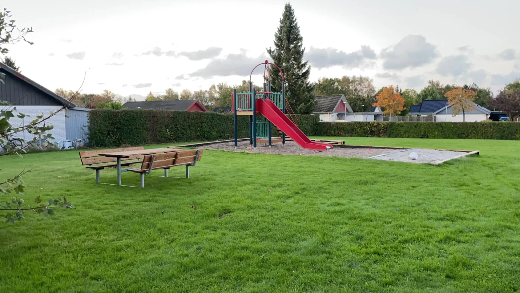 Legeplads i Højgårdsparken med rutsjebane, sandkasse og grønne arealer